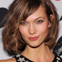 Karlie Kloss Wild Soft Curly Bob Hairstyle with Long Side Swept Bangs