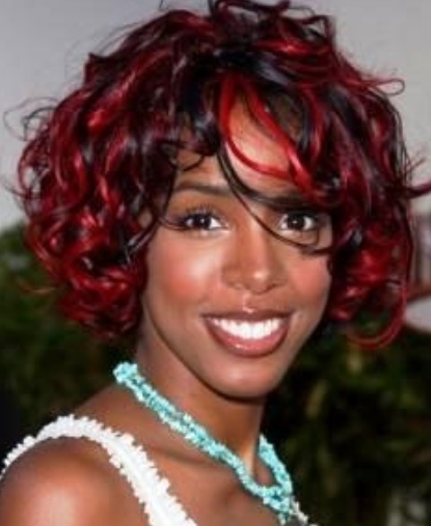 Kelly Rowland Hairstyles: Medium Curls with Red Highlights