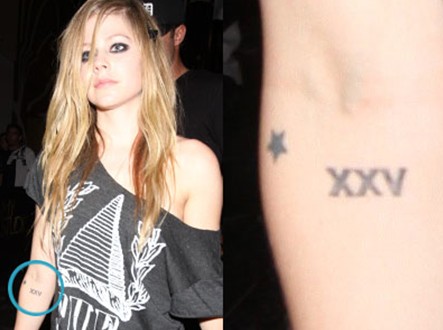 Avril Lavigne tattoos - star and XXV tattoos right elbow